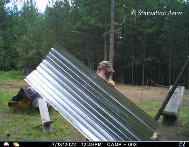 Carrying a sheet of roofing metal.